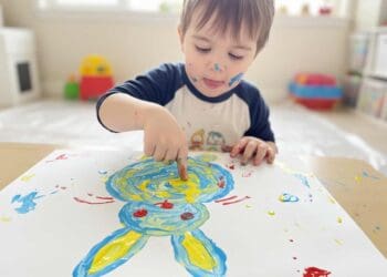 Kind malt einen Osterhasen mit Fingerfarbe